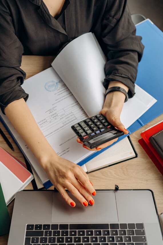 Image décrivant une femme avec une calculatrice et un ordinateur